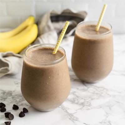 Chocolate peanut butter protein smoothie with banana, cocoa, and protein powder in a glass
