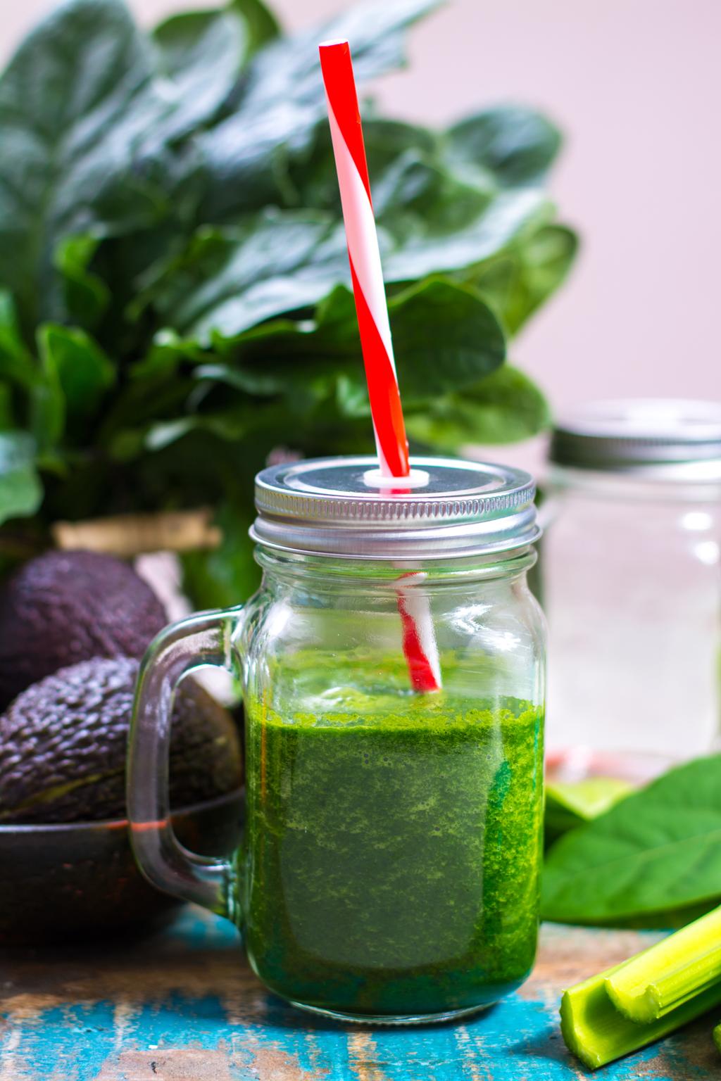 Fresh green detox smoothie made with spinach, cucumber, pineapple, and lemon in a glass"