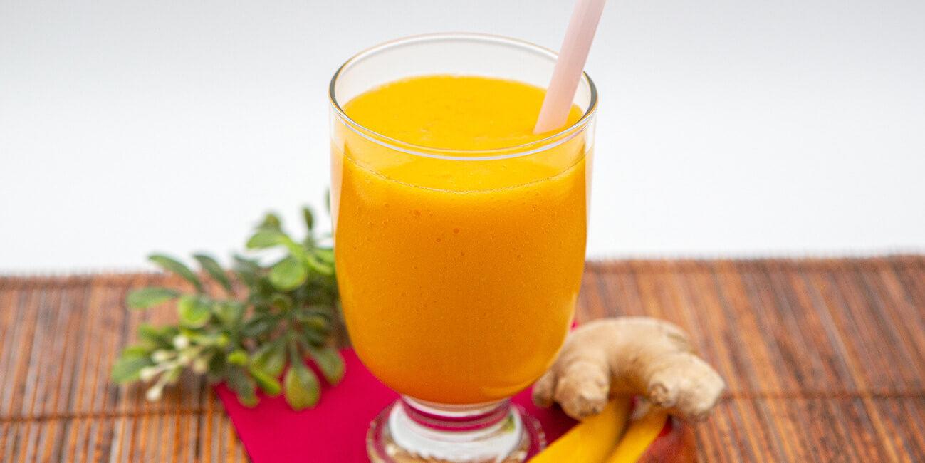 Tropical mango ginger smoothie with fresh mango, banana, and lime in a glass